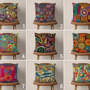 May include: Nine colorful throw pillows with geometric patterns and designs. The pillows are arranged in three rows of three, each pillow on a brown wooden chair.