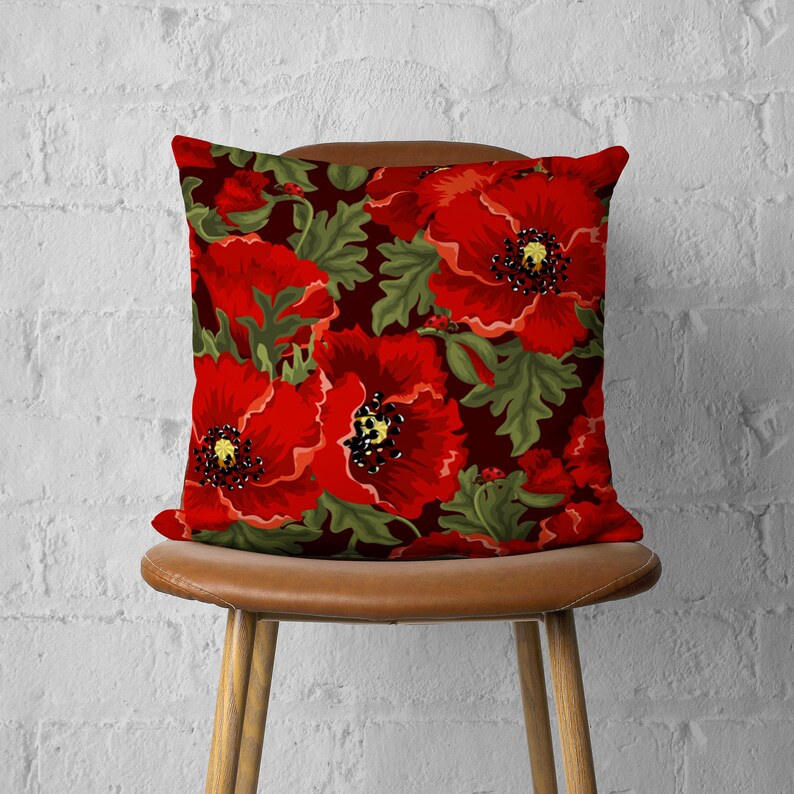 Puede incluir: Funda de coj&iacute;n roja con estampado de amapolas sobre fondo verde oscuro. La funda de coj&iacute;n presenta un patr&oacute;n floral con amapolas rojas y hojas verdes.