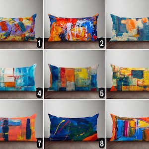Peut inclure: Dix coussins décoratifs colorés avec des motifs abstraits dans des tons de bleu, jaune, orange et rouge. Les coussins sont disposés en trois rangées de trois, avec un numéro sous chaque coussin.