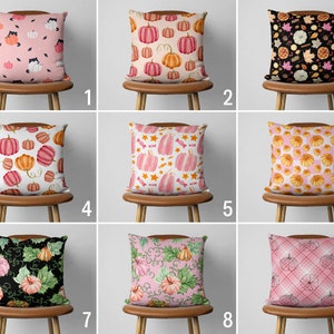 May include: Nine different pillow designs featuring various fall-themed patterns. The pillows are all pink, white, and black with various patterns including pumpkins, leaves, and candy.