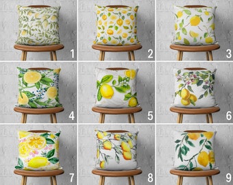 Peut inclure: Neuf designs de coussins différents mettant en scène des citrons et de la verdure. Les coussins sont tous blancs avec une variété de motifs de citrons et de feuilles. Les coussins sont présentés sur des chaises en bois contre un mur en briques blanches.
