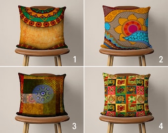 May include: Four decorative throw pillows with different colorful patterns. The pillows are on brown chairs with wooden legs. The pillows are all square and have a variety of geometric and floral designs.