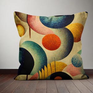 Op de afbeelding: Een decoratief kussen met een geometrisch patroon van overlappende cirkels in tinten blauw, groen, geel, oranje, roze en bruin. De cirkels zijn willekeurig gerangschikt op een cr&egrave;mekleurige achtergrond.