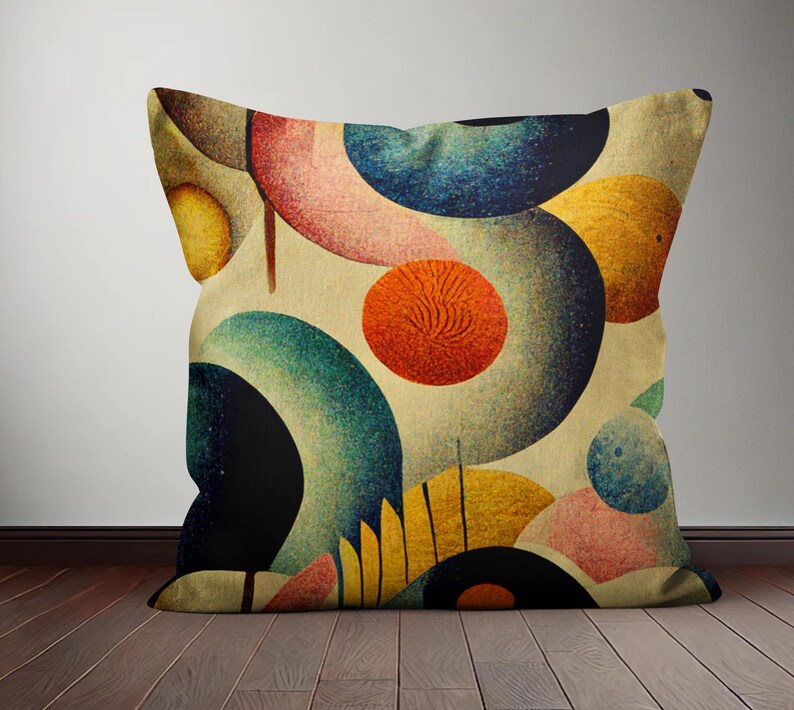 Op de afbeelding: Een decoratief kussen met een geometrisch patroon van overlappende cirkels in tinten blauw, groen, geel, oranje, roze en bruin. De cirkels zijn willekeurig gerangschikt op een cr&egrave;mekleurige achtergrond.