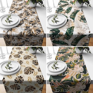 Puede incluir: Cuatro caminos de mesa diferentes con patrones de hojas tropicales. Los caminos de mesa son todos blancos con hojas y patrones de diferentes colores. Los caminos de mesa miden todos 35,5 cm de ancho y 177,8 cm de largo.