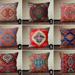 Op de afbeelding: Negen decoratieve kussens met verschillende kleurrijke geometrische patronen. De kussens zijn allemaal vierkant en hebben een rood, blauw en groen kleurenschema.