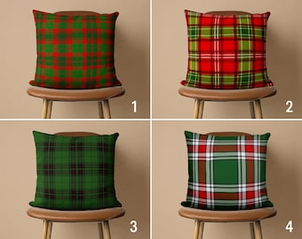 May include: Four decorative throw pillows with a plaid pattern in shades of red, green, and white. The pillows are arranged on four wooden chairs with brown leather seats.