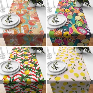 Può includere: Quattro runner da tavolo con diversi disegni di frutta. Il primo runner ha un disegno di anguria, ananas e kiwi. Il secondo runner ha un disegno di frutta tropicale con banane, ananas e mango. Il terzo runner ha un disegno di limone con limoni su uno sfondo a strisce rosso e bianco. Il quarto runner ha un disegno di limone con limoni su uno sfondo rosa.