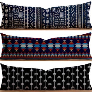 May include: Three decorative throw pillows with different geometric patterns. The first pillow has a white and blue geometric pattern. The second pillow has a blue, red, and white geometric pattern. The third pillow has a black and white arrow pattern.