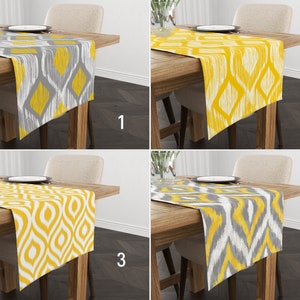 May include: Four different table runners with a yellow and gray geometric pattern. The table runners are shown on wooden tables with chairs.