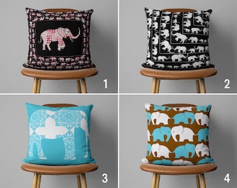 Op de afbeelding: Vier decoratieve kussens met verschillende olifantontwerpen. De kussens staan op bruine houten stoelen tegen een lichtgrijze achtergrond. Alle kussens zijn vierkant en hebben verschillende kleuren en patronen.