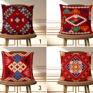 Könnte beinhalten: Vier dekorative Kissen mit geometrischen Mustern in Rot, Orange und Blau. Jedes Kissen ist quadratisch und hat ein anderes Design, darunter Rauten-, Dreiecks- und Kreuzmotive. Die Kissen werden auf einem Holzstuhl präsentiert.