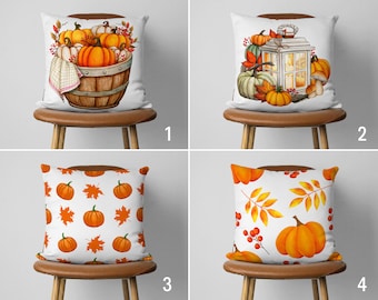 May include: Four different pillow designs featuring autumnal themes. The first pillow has a basket of pumpkins with fall leaves. The second pillow has a lantern with pumpkins and fall leaves. The third pillow has a repeating pattern of pumpkins and fall leaves. The fourth pillow has a repeating pattern of fall leaves and berries with a large pumpkin in the center.