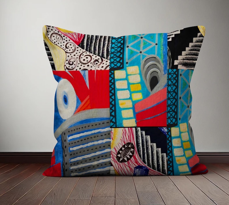 Op de afbeelding: Een kleurrijk kussen met een geometrisch patroon in tinten rood, blauw, geel, zwart en wit. Het kussen is gemaakt van stof en heeft een vierkante vorm.