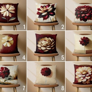 May include: Nine different throw pillow designs featuring a large, stylized flower in shades of cream and burgundy on a cream or burgundy background.