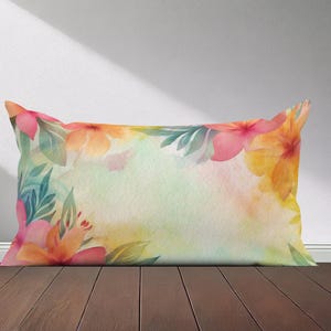 Peut inclure: Un oreiller rectangulaire avec un motif aquarelle de fleurs tropicales roses, jaunes et vertes. L'oreiller est sur une surface en bois.