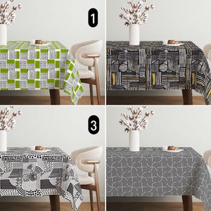 May include: Four different tablecloths with geometric patterns. The tablecloths are black and white with accents of green, yellow, and gold. The tablecloths are shown on a table with a white background.