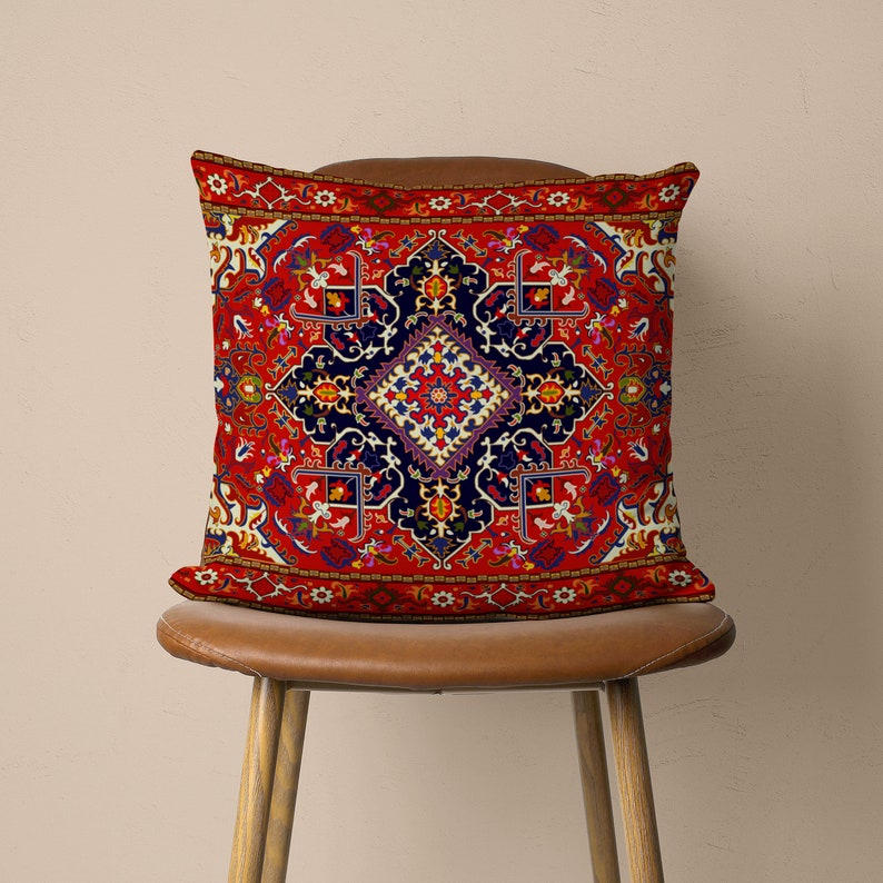 May include: Red cushion with a colourful, intricate patterned design inspired by traditional Persian rugs. The cushion features a central diamond shape with floral motifs and geometric patterns.