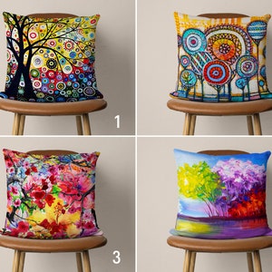May include: Four colorful throw pillow covers with different abstract floral and tree designs. The pillows are displayed on brown chairs with wooden legs.