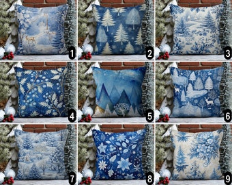 Könnte beinhalten: Neun dekorative Zierkissen mit winterlichen Motiven. Die Kissen zeigen verschiedene blau-weiße Muster, darunter Winterlandschaften, Bäume und florale Motive. Jedes Kissen hat ein einzigartiges Design und bietet eine Reihe von Stilen für die Inneneinrichtung.