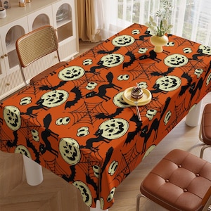 May include: Orange tablecloth with a Halloween theme featuring black bats, spiderwebs, and jack-o'-lantern faces.