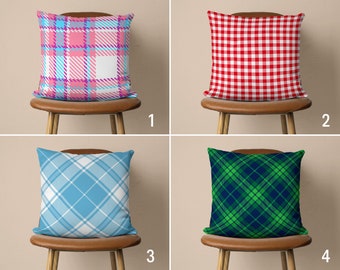 May include: Four different patterned throw pillows on chairs. The pillows are pink and blue plaid, red gingham, blue and white plaid, and green and black plaid.