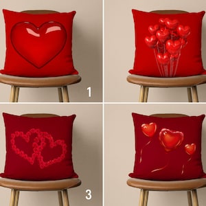 May include: Four red throw pillows with different heart designs. The pillows are on brown chairs with a light brown background.