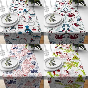 May include: Four different Christmas table runners with various designs. The first runner features a white background with red, blue, and black illustrations of snowmen, presents, and birds. The second runner has a white background with green, red, and blue illustrations of squirrels, berries, and birds. The third runner has a white background with red, blue, and black illustrations of trees, snowflakes, and birds. The fourth runner has a white background with green, red, and black illustrations of trees, snowflakes, and candy canes. The text "Merry Christmas" is printed on the runner.
