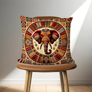 May include: A decorative throw pillow with a colorful mandala design featuring an elephant in the center. The mandala is made up of geometric shapes and patterns in shades of red, orange, yellow, blue, green, and brown.