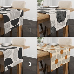 Peut inclure: Quatre chemins de table différents avec des motifs géométriques. Les chemins de table sont beiges avec des motifs noirs et blancs, ou beiges avec des motifs orange et blancs. Les chemins de table sont présentés sur des tables en bois avec des chaises.