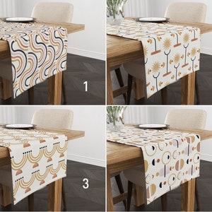 Op de afbeelding: Vier verschillende tafelrunners met geometrische patronen in tinten bruin, geel, wit en zwart. De runners worden getoond op houten tafels met stoelen.