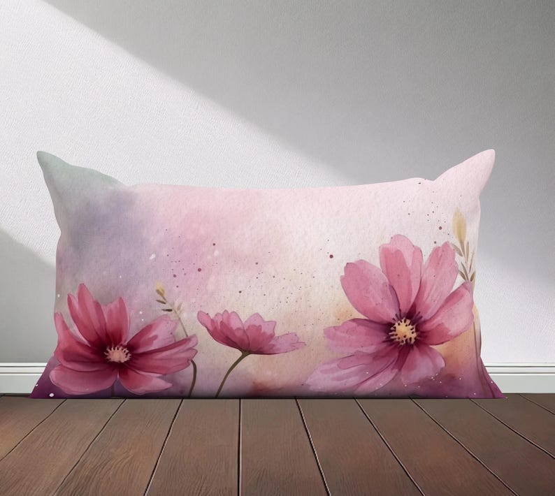 Peut inclure: Un oreiller rose et violet avec un motif aquarelle de fleurs roses. Les fleurs ont un aspect doux et d&eacute;lav&eacute; et sont dispos&eacute;es dans un motif l&acirc;che et fluide.