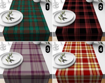 May include: Four plaid table runners in different color schemes: green and red, black and red, purple and gray, and red and yellow. Each runner is displayed on a white table with a white plate and decorative sprig.