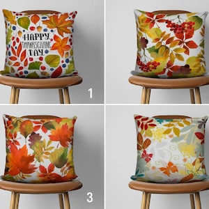 Peut inclure: Quatre coussins décoratifs avec différents motifs sur le thème de l'automne. Les coussins sont sur des chaises brunes avec un fond blanc. Le premier coussin a un fond blanc avec des feuilles rouges, orange et jaunes et le texte "Happy Thanksgiving Day". Le deuxième coussin a un fond blanc avec des baies rouges, des feuilles vertes et des feuilles orange. Le troisième coussin a un fond blanc avec des feuilles rouges, orange et jaunes. Le quatrième coussin a un fond blanc avec des feuilles vertes, jaunes et orange.