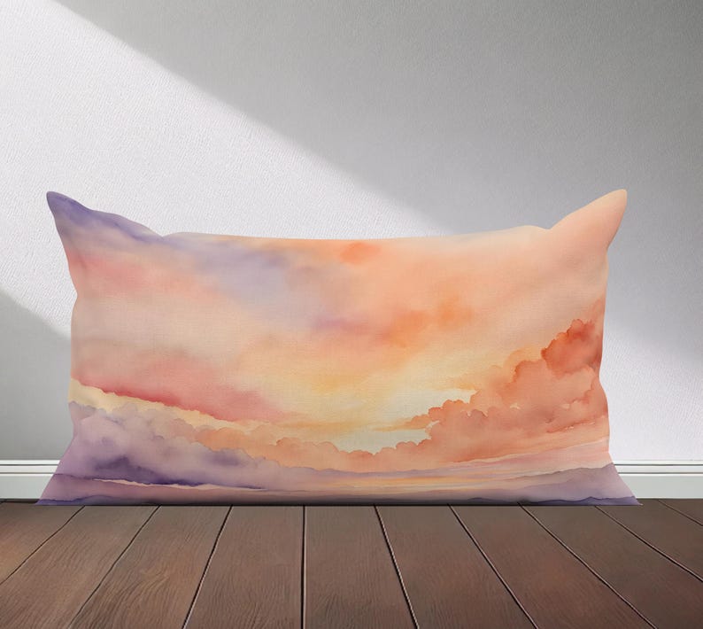 Peut inclure: Un coussin rectangulaire avec une peinture aquarelle d'un ciel de coucher de soleil. Le ciel est un m&eacute;lange de teintes orange, rose et violette avec des nuages blancs moelleux.