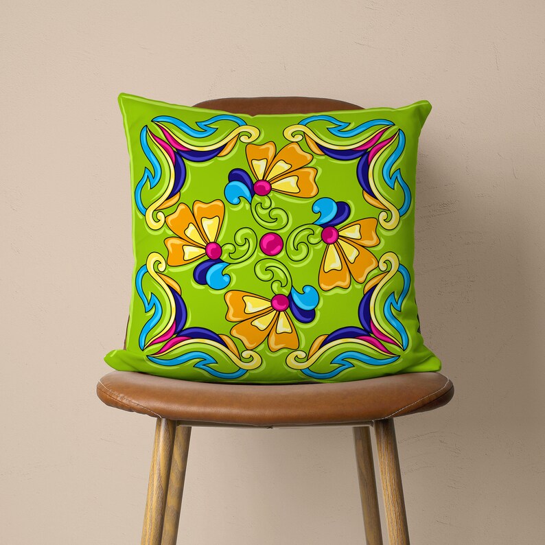 May include: A green cushion with a colourful floral pattern. The cushion features a repeating design of stylised flowers with blue, yellow, pink, and orange accents.
