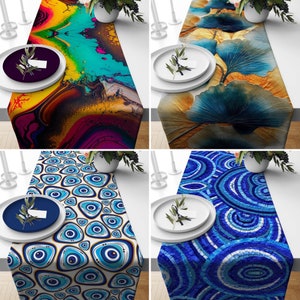 May include: Four different table runners with abstract designs. The first runner has a colorful abstract design with yellow, blue, red, and purple colors. The second runner has a blue and yellow abstract design with a large leaf shape. The third runner has a blue and white abstract design with a pattern of eyes. The fourth runner has a blue and white abstract design with a pattern of circles.
