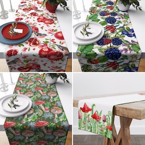 May include: Four different table runners with various designs. The first runner features a white background with red and green fruits, birds, and leaves. The second runner has a white background with blackberries, blueberries, and green leaves. The third runner has a green background with red and white mushrooms. The fourth runner has a white background with red and green flowers and leaves.