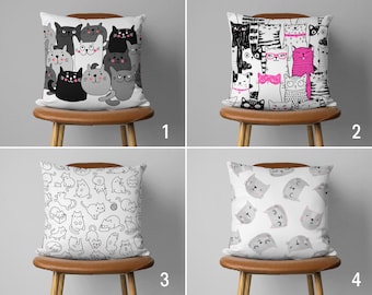 May include: Four different pillow designs featuring black and white illustrations of cats. The first pillow has a group of cats with different expressions. The second pillow has a group of cats wearing glasses and hats. The third pillow has a pattern of cats in various poses. The fourth pillow has a pattern of cat faces.