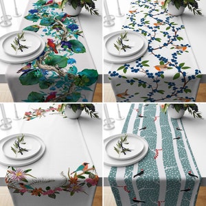 May include: Four table runners with different nature-themed designs. One features birds and flowers, another has blue berries and birds, a third showcases flowers and birds, and the last one has birds and trees.
