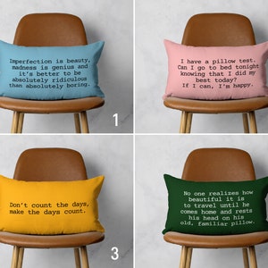 Può includere: Quattro cuscini decorativi con citazioni ispiratrici stampate su di essi. I cuscini sono esposti su sedie marroni con gambe in legno. I cuscini sono blu, rosa, gialli e verdi.