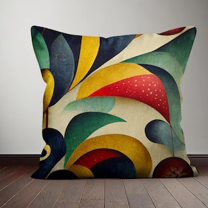 Op de afbeelding: Een decoratief kussen met een geometrisch patroon met abstracte vormen in tinten rood, geel, blauw en groen. Het kussen heeft een cr&egrave;mekleurige achtergrond.