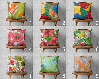 May include: Nine different pillow covers with various floral and tropical patterns. The pillows are displayed on wooden chairs with a white brick wall background.