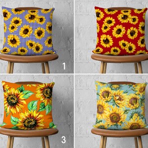 May include: Four different pillow designs featuring sunflowers. The pillows are displayed on brown chairs with a white brick background. The first pillow has a blue and white gingham pattern with sunflowers. The second pillow has a red background with sunflowers. The third pillow has an orange background with sunflowers. The fourth pillow has a light blue background with sunflowers.