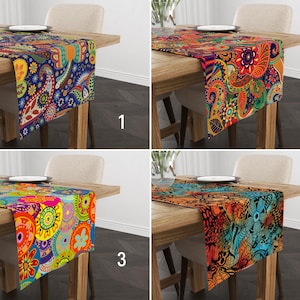 May include: Four table runners with different paisley patterns. The runners are on wooden tables and are in various colours, including blue, red, orange, yellow, and green.