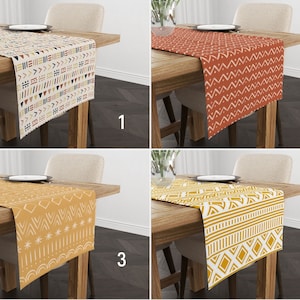 May include: Four different table runners with geometric patterns. The runners are in various colours, including beige, yellow, orange, and red. The runners are all approximately 35 cm wide and 178 cm long.
