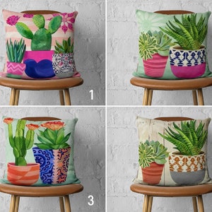Pode incluir: Quatro designs de almofadas diferentes com ilustrações coloridas de cactos e suculentas em vasos. As almofadas são exibidas em cadeiras de madeira marrom contra um fundo de parede de tijolo branco.