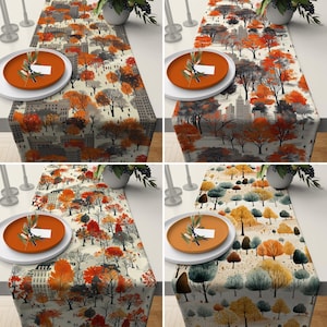 May include: Four table runners with a autumnal design featuring colourful trees and buildings. The runners are on a white background and have a subtle watercolour effect.