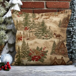 May include: A decorative throw pillow with a winter woodland scene featuring a cabin, trees, and animals. The background is a beige color with a subtle pattern. The pillow is made of a soft, brown fabric.