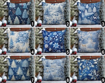 Könnte beinhalten: Zehn verschiedene blaue und weiße gemusterte Kissenbezüge mit winterlichen Feiertagsmotiven. Die Kissen zeigen Designs mit Schneeflocken, Kiefern und Winterszenen.